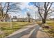 Ranch style home featuring a long driveway and attached garage with mature trees on a large lot at 1731 N Campbell Ave, Indianapolis, IN 46218