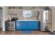 Bright kitchen with updated stainless steel appliances and contrasting blue cabinets, laminate flooring at 1731 N Campbell Ave, Indianapolis, IN 46218