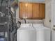 This laundry room features overhead cabinets and a modern washer and dryer at 1731 N Campbell Ave, Indianapolis, IN 46218