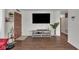 Cozy living room featuring laminate floors, a TV, and a wooden front door with a security peephole at 1731 N Campbell Ave, Indianapolis, IN 46218