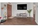 Cozy living room featuring laminate floors, a TV, and a wooden front door with a security peephole at 1731 N Campbell Ave, Indianapolis, IN 46218
