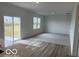 Open-concept living area with neutral carpet, and sliding glass doors leading to the outside at 2109 Boxwood Dr, Greenfield, IN 46140