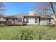 The level backyard features a wooden deck, mature trees, and plenty of space for outdoor activities at 2231 Reston Ln, Columbus, IN 47203