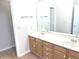 Bright bathroom featuring a double sink, wooden cabinets, and an expansive mirror at 2231 Reston Ln, Columbus, IN 47203