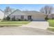 Charming ranch-style home with a brick facade, attached garage, and manicured front lawn on a sunny day at 2231 Reston Ln, Columbus, IN 47203