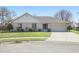 Charming ranch-style home with a brick facade, attached garage, and manicured front lawn on a sunny day at 2231 Reston Ln, Columbus, IN 47203