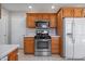 Functional kitchen with stainless steel appliances, wooden cabinetry, and tiled floors at 2231 Reston Ln, Columbus, IN 47203