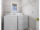 Bright laundry room featuring a washer, dryer, shelving, and natural light at 2231 Reston Ln, Columbus, IN 47203