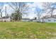Expansive backyard featuring lush green grass, mature trees, and a carport, perfect for outdoor activities at 2305 S Rybolt Ave, Indianapolis, IN 46241