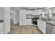 Bright kitchen with stainless steel appliances, granite countertops, white cabinets, and hardwood floors at 2305 S Rybolt Ave, Indianapolis, IN 46241