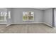 Neutral living room features natural light through two windows and a seamless flow into adjacent rooms at 2305 S Rybolt Ave, Indianapolis, IN 46241