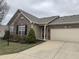 Inviting home with brick accents, well-manicured landscaping, attached garage, and a concrete driveway at 2610 Big Bear Ln, Indianapolis, IN 46217