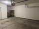 Spacious, empty garage with concrete floors, shelving unit, and overhead door opener at 2610 Big Bear Ln, Indianapolis, IN 46217