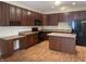 Kitchen with dark wood cabinets, center island, modern appliances, and wood flooring at 2610 Big Bear Ln, Indianapolis, IN 46217