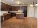 Open kitchen with island, black appliances, and dark wood cabinets at 2610 Big Bear Ln, Indianapolis, IN 46217