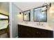 Bathroom with dual sinks, dark wood cabinetry, and large mirrors, complete with modern fixtures at 2700 Yellowwood Ct, Columbus, IN 47203