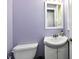 Powder room with small vanity, toilet, mirror and light purple paint at 2700 Yellowwood Ct, Columbus, IN 47203