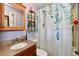 Bathroom featuring granite countertop, natural wood mirror, towel rack, and shower with modern shower curtain at 2700 Yellowwood Ct, Columbus, IN 47203