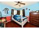 Bedroom with a ceiling fan, hardwood floors, and two-toned walls with cartoon decals at 2700 Yellowwood Ct, Columbus, IN 47203