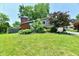 Charming home with a brick chimney, lush green lawn, and mature trees offering curb appeal at 2700 Yellowwood Ct, Columbus, IN 47203