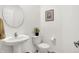 Bright half-bathroom with a pedestal sink, toilet, and simple decor, offering a clean and functional space at 2795 Lanai Ln, Greenwood, IN 46143