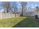 Large backyard featuring a grassy area, a wooden fence, and mature trees for privacy at 3109 Welch Dr, Indianapolis, IN 46224