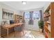 Bright home office featuring a wooden desk, bookshelves, and natural light from large windows at 3109 Welch Dr, Indianapolis, IN 46224