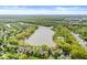 Gorgeous aerial showcasing a scenic lake surrounded by beautiful homes and mature trees at 3539 Clearwater Cir, Indianapolis, IN 46240