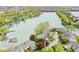 Scenic aerial view of homes nestled along a tranquil lake, surrounded by lush greenery and mature trees at 3539 Clearwater Cir, Indianapolis, IN 46240