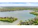Expansive aerial view of lakefront homes with private docks surrounded by lush trees and blue skies at 3539 Clearwater Cir, Indianapolis, IN 46240