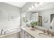 Bright bathroom featuring a double vanity, bathtub, and a window with a view of the outside at 3539 Clearwater Cir, Indianapolis, IN 46240