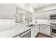 Bright kitchen with white cabinets, brick backsplash, stainless steel appliances and granite countertops at 3539 Clearwater Cir, Indianapolis, IN 46240