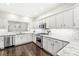Modern kitchen features white cabinets, granite countertops, stainless steel appliances, and dark hardwood floors at 3539 Clearwater Cir, Indianapolis, IN 46240