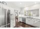 Modern kitchen featuring stainless steel refrigerator, granite counters, white cabinetry and hardwood flooring at 3539 Clearwater Cir, Indianapolis, IN 46240