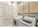 Functional laundry room with white cabinets and modern washer and dryer units at 3539 Clearwater Cir, Indianapolis, IN 46240