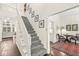 Bright staircase and landing features carpeted steps, white railings and hardwood floors at 3539 Clearwater Cir, Indianapolis, IN 46240