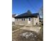 Exterior view of a home featuring a black metal roof, neutral siding, and a white back door at 354 Bloomingdale Rd, Montezuma, IN 47862