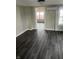 Spacious living room with gray wood-look flooring and mini-split air conditioner at 354 Bloomingdale Rd, Montezuma, IN 47862