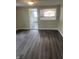 View of the living room to kitchen space with gray wood-look flooring at 354 Bloomingdale Rd, Montezuma, IN 47862