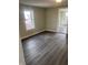 View of the living room with gray wood-look flooring and fresh neutral paint at 354 Bloomingdale Rd, Montezuma, IN 47862