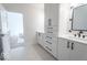 A bright bathroom boasts double sinks, black fixtures, white cabinetry, and light tile flooring at 395 Breakwater Dr, Fishers, IN 46037