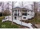 Exterior shot of a modern home featuring an elevated balcony, a retaining wall, and lush landscaping at 395 Breakwater Dr, Fishers, IN 46037