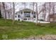 Exterior view of a modern home featuring a spacious lawn, retaining wall, and mature trees at 395 Breakwater Dr, Fishers, IN 46037