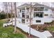 An exterior shot of the home featuring a two-story balcony, retaining wall, and a sloping lawn at 395 Breakwater Dr, Fishers, IN 46037
