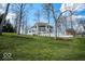 Exterior shot of a modern home with large windows, a sprawling lawn, and mature trees at 395 Breakwater Dr, Fishers, IN 46037