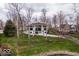 Aerial view of a modern home featuring a pond, landscaping, and mature trees surrounding the property at 395 Breakwater Dr, Fishers, IN 46037