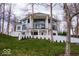 Exterior of a modern home with expansive windows, a covered patio and a manicured lawn at 395 Breakwater Dr, Fishers, IN 46037