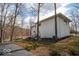 Back of home featuring a textured white exterior, steps to upper level, and green landscaping at 395 Breakwater Dr, Fishers, IN 46037