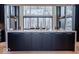 Stunning kitchen island with dark cabinets and white marble countertop and floor-to-ceiling windows at 395 Breakwater Dr, Fishers, IN 46037