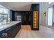 Modern kitchen boasts dark cabinets, gold hardware, and a large island with white marble countertop at 395 Breakwater Dr, Fishers, IN 46037